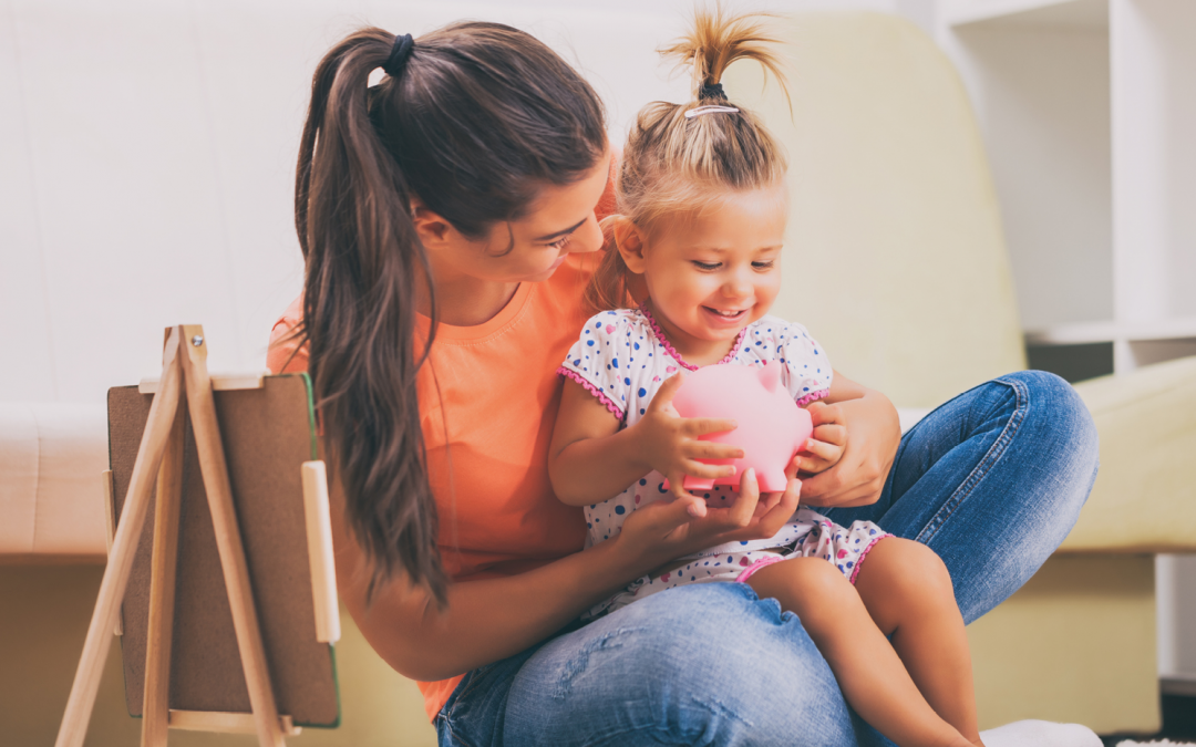 mom and daughter holding piggy bank