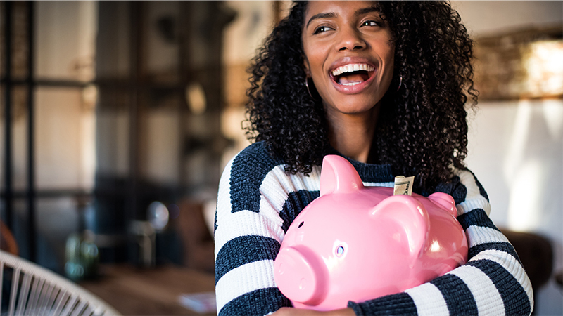 Woman holding large piggy bank