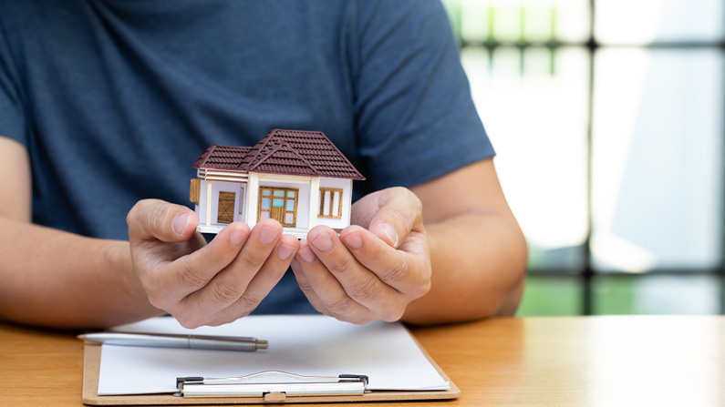 Man holding small model of house in his hands