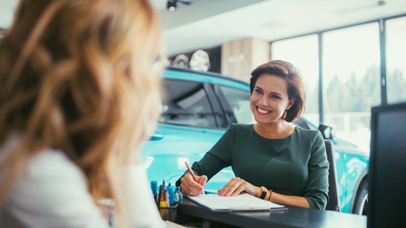 woman signing car papers