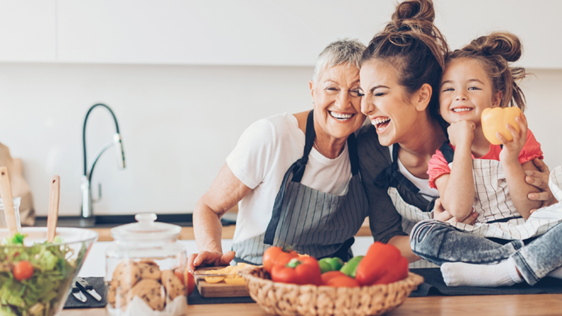 three generations of women in kitchen smiling